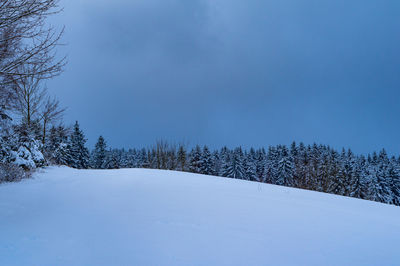 Snow covered land against sky