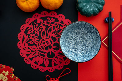 Chinese lunar new year decoration over red and black background. flat lay dinning table concept.