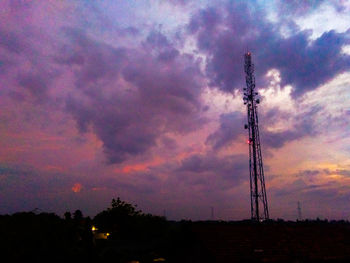 Low angle view of silhouette communications tower against sky during sunset