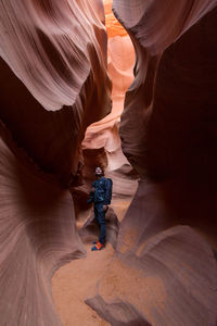 Full length of tourist standing amidst rock formations in desert