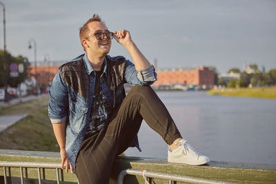 Smiling young man looking away against sky