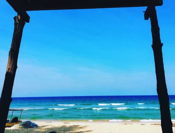 Scenic view of beach against clear blue sky