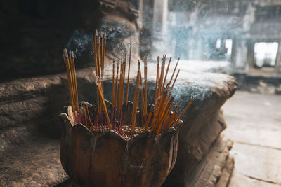 Incense sticks burning with smoke in ancient temple in cambodia.