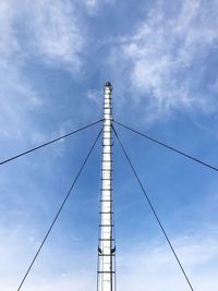 Low angle view of electricity pylon against blue sky