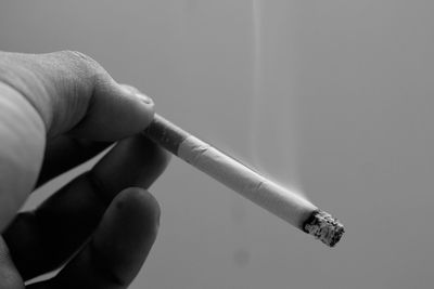 Close-up of hand holding cigarette