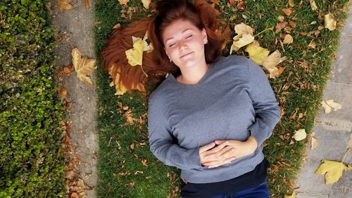 Portrait of happy woman standing on footpath during autumn