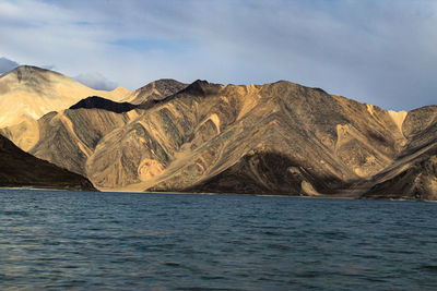 Scenic view of sea and mountains against sky