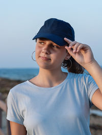 Teenager standing by the sea at sunset