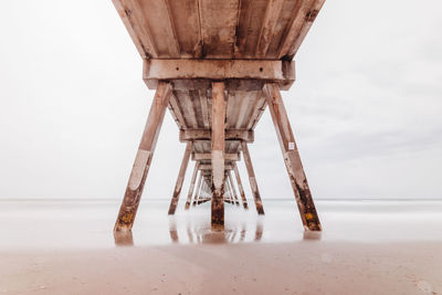 View of pier on beach against sky