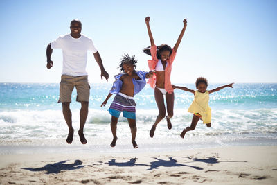 Rear view of family walking at beach