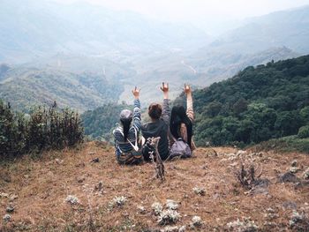 Friends on mountain against sky