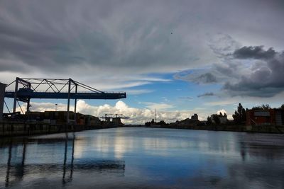 Bridge over river against sky in city