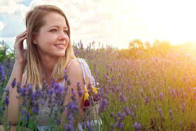 Beautiful woman on field against cloudy sky