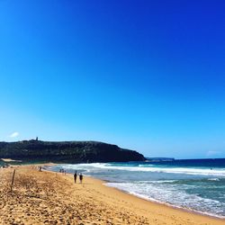 Scenic view of beach against blue sky