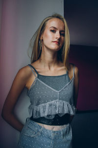 Young woman standing against wall