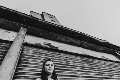 Low angle portrait of woman against sky