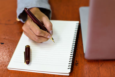 Midsection of man reading book on table