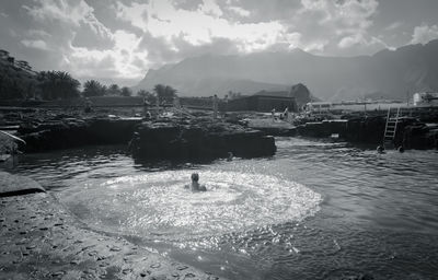 People swimming in sea against sky