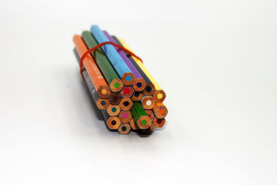 High angle view of colored pencils against white background