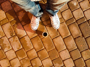 Low section of man standing on tiled floor