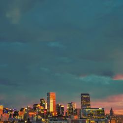 Illuminated buildings in city against sky