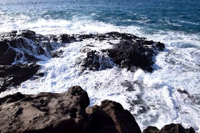 Scenic view of waves breaking on rocks