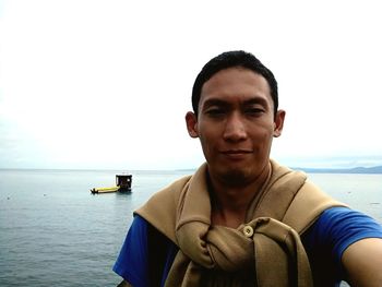 Portrait of young man against sea