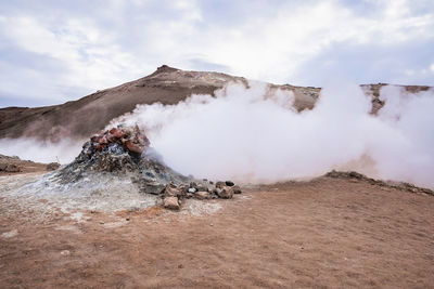 View of steam emitting from fumarole in geothermal area of hverir against sky