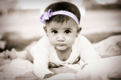 Portrait of cute baby lying on bed