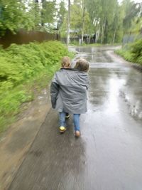 Rear view of boys walking on water