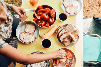 Breakfast prepared during summer vacation on camping. bread, cottage cheese, cold meat, tomatoes