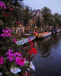 Boats in canal by buildings in city