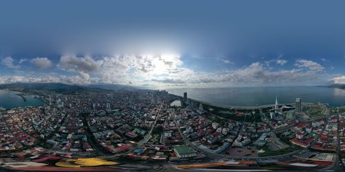 Panoramic view of city against cloudy sky