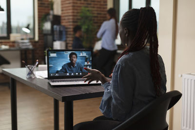 Rear view of businesswoman talking on video conference