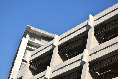 Low angle view of modern building against clear blue sky