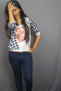 Young woman standing against wall