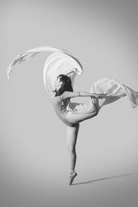 Reflection of young woman in mid-air over white background