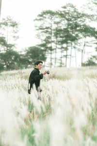 Portrait of man with his camera in the middle of white reeds