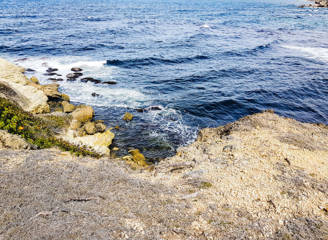 HIGH ANGLE VIEW OF ROCKS ON SHORE AT BEACH