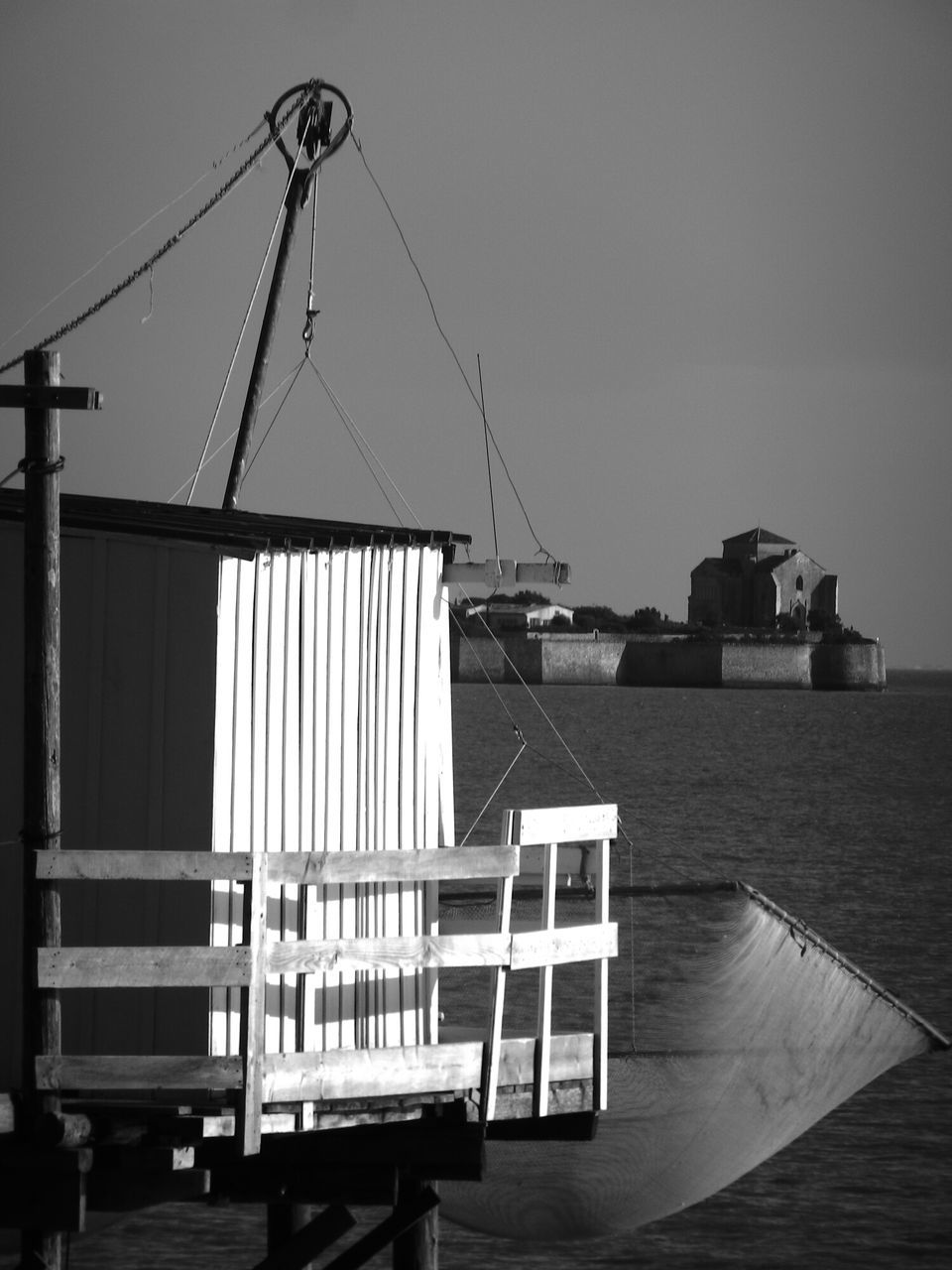 clear sky, sea, built structure, building exterior, architecture, copy space, water, sky, nautical vessel, day, horizon over water, outdoors, no people, transportation, crane - construction machinery, boat, nature, harbor, pier, sunlight