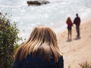 Rear view of mature woman at beach during sunny day