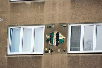 Low angle view of window hanging on building