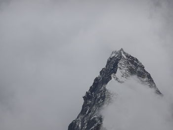 Low angle view of snowcapped mountain against sky