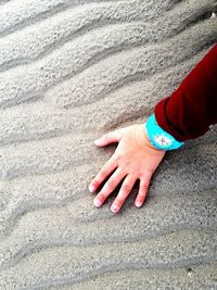 High angle view of hands on sand