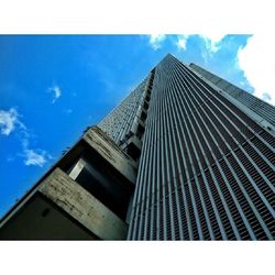 Low angle view of modern building against cloudy sky