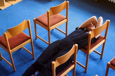 High angle view of woman lying on chairs