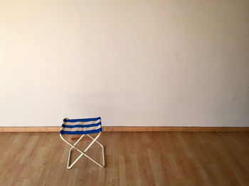 Seat on hardwood floor against white wall