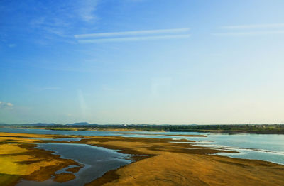 Scenic view of beach against blue sky