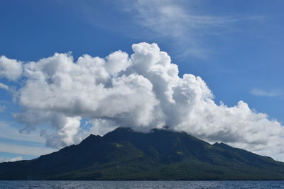 Scenic view of sea and mountains against blue sky