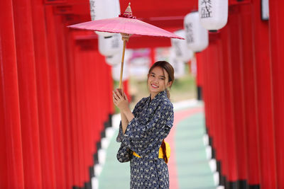 Woman standing with red umbrella
